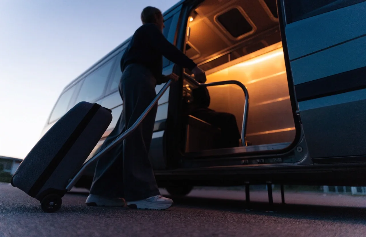 Traveller boarding an airport parking shuttle at dusk
